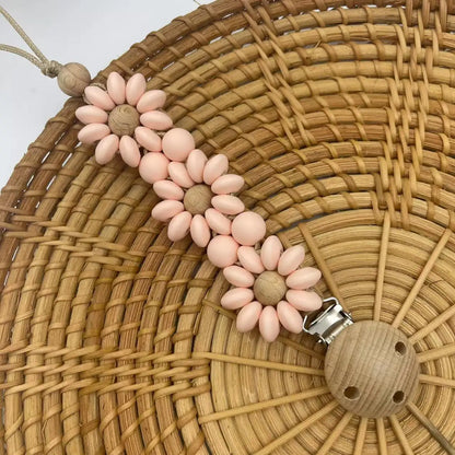 Attache Tétine Petite Fleur Marguerite, un accessoire joli et pratique pour garder la tétine à portée de main.